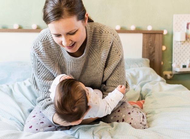 Photo gratuite heureuse mère tenant son bébé dans les bras