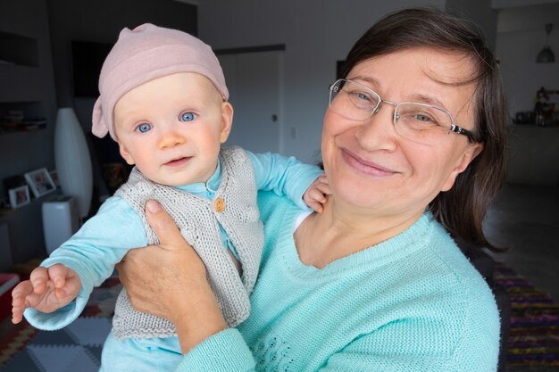 Heureuse nouvelle grand-mère posant avec une mignonne petite-fille