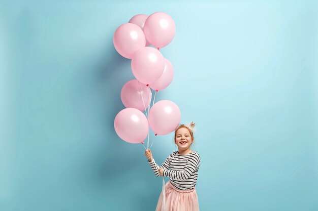 Heureuse petite fille tenant des ballons