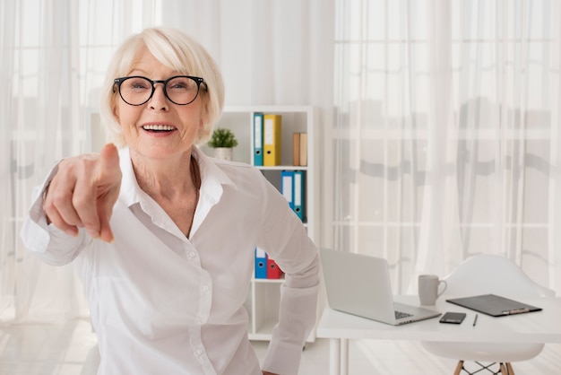 Photo gratuite heureuse vieille femme dans son bureau