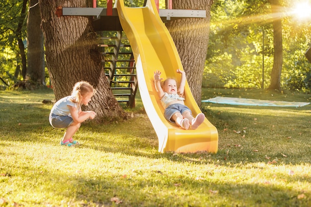 Heureuses petites filles dévalant la colline sur le terrain de jeu