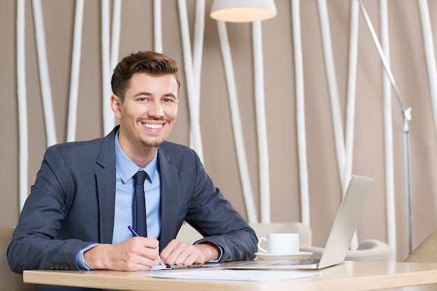 Photo gratuite heureux d'affaires des adultes travaillant au bureau dans le bureau