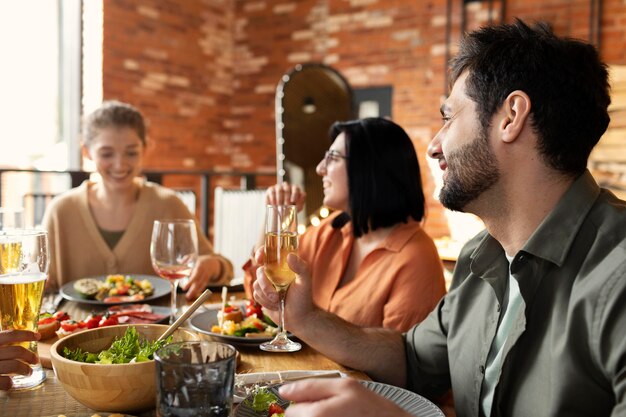 Heureux amis assis à table coup moyen