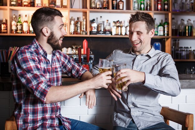 Heureux amis, boire de la bière au comptoir au pub