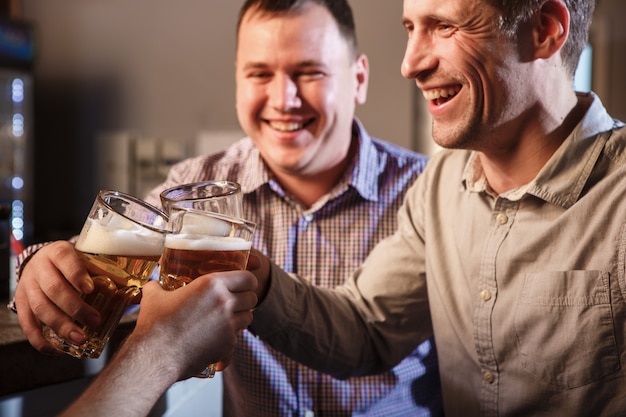 Heureux amis, boire de la bière au comptoir au pub