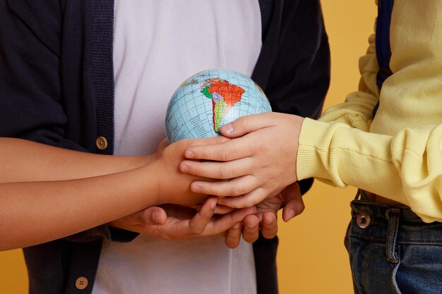 Heureux amis de l'école tenant un globe terrestre