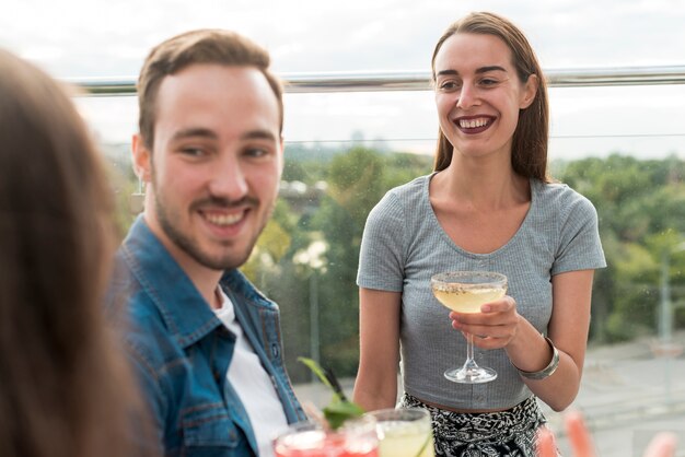 Photo gratuite heureux amis lors d'une fête en terrasse
