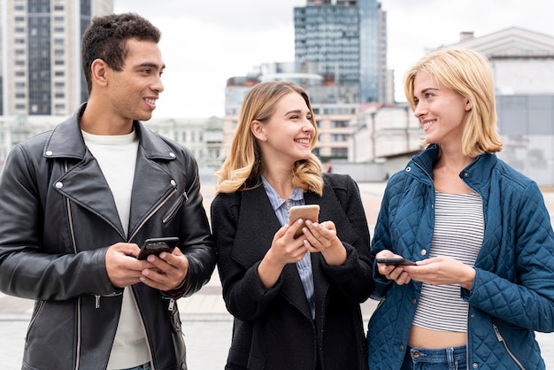 Photo gratuite heureux amis avec les téléphones mobiles