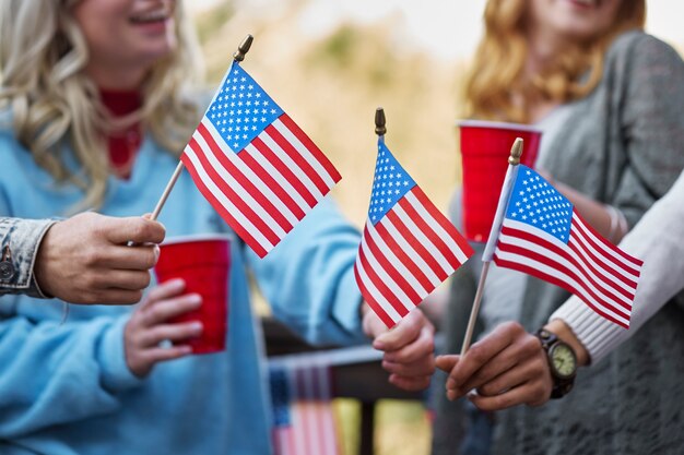 Heureux amis tenant des drapeaux américains