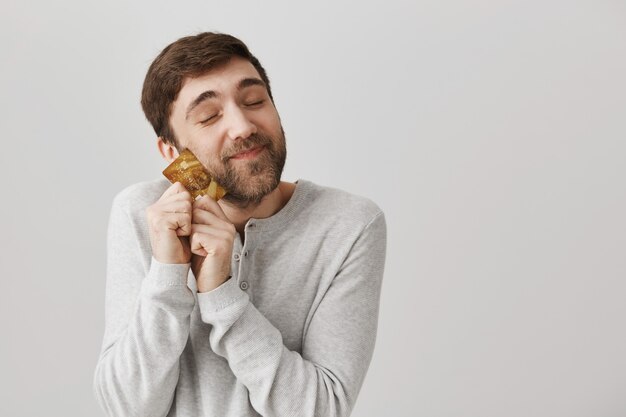 Heureux barbu heureux étreignant une carte de crédit froide