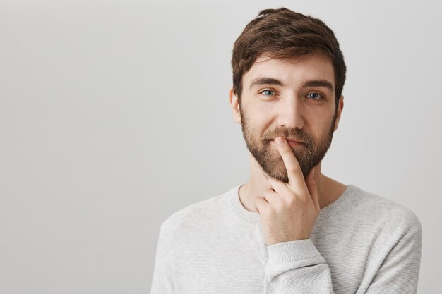 Heureux beau mec sourire narquois comme avoir une idée, penser