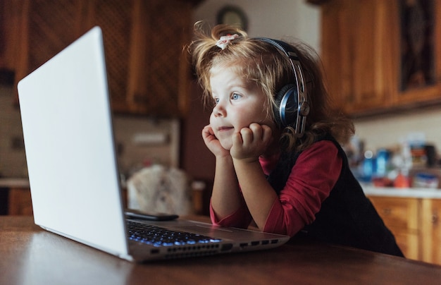 Heureux bel enfant dans les écouteurs, écouter de la musique