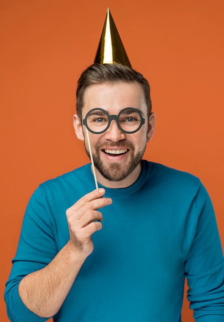 Photo gratuite heureux bel homme posant avec de fausses lunettes