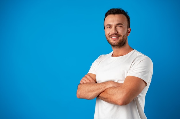 Heureux bel homme souriant sur fond bleu