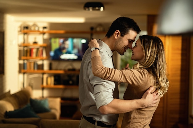 Heureux couple amoureux touchant le nez en dansant à la maison