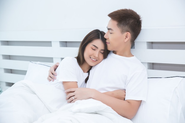 Heureux couple asiatique sur le lit à la maison