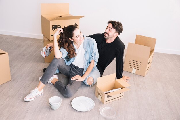 Heureux couple assis dans un nouvel appartement