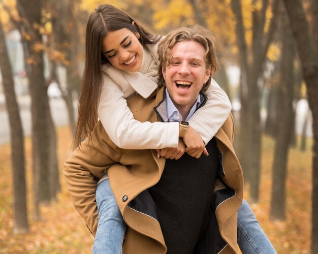 Heureux couple caucasien étreignant et souriant dans le parc à l'automne