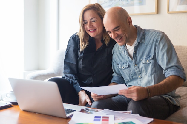 Heureux couple de clients parlant à un architecte d'intérieur