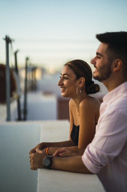 Heureux couple debout sur le balcon et passer du temps romantique ensemble
