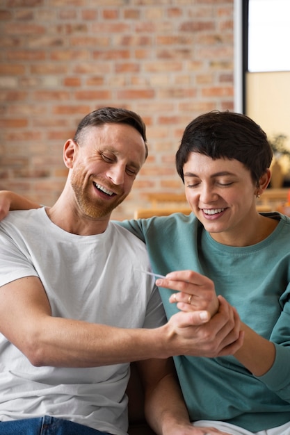 Heureux couple découvrant qu'ils vont être parents sur la base d'un test de grossesse