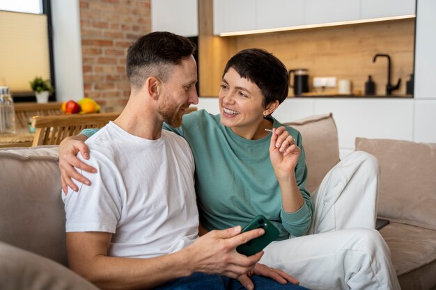 Heureux couple découvrant qu'ils vont être parents sur la base d'un test de grossesse