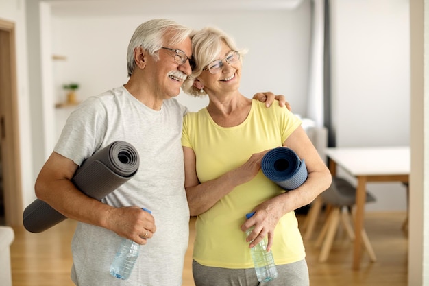 Heureux couple mature embrassant après avoir travaillé à la maison