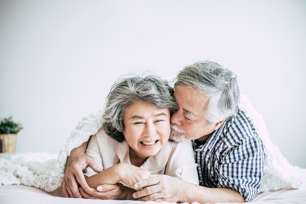Heureux couple de personnes âgées rire dans la chambre