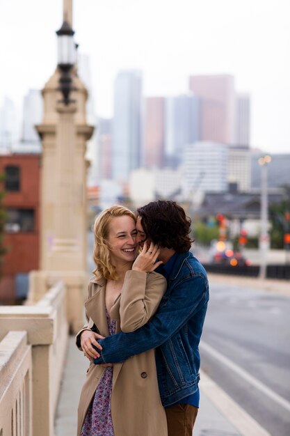 Heureux couple posant à l'extérieur de la ville avec bague de fiançailles