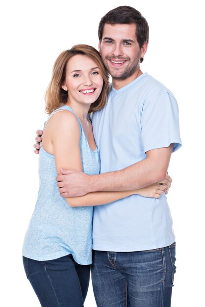 Heureux couple souriant debout ensemble regardant la caméra - isolé