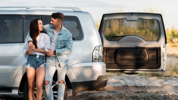 Heureux couple de touristes et leur voiture