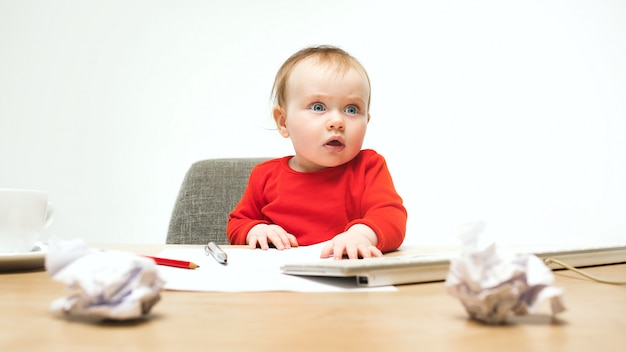 Heureux enfant bébé fille bambin assis avec clavier d'ordinateur isolé