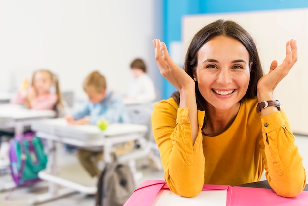 Heureux enseignant assis à son bureau