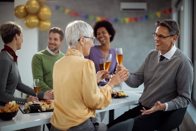 Heureux entrepreneurs portant un toast au champagne lors d'une fête au bureau