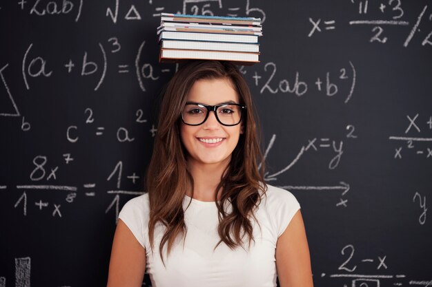 Heureux étudiant avec des livres sur sa tête