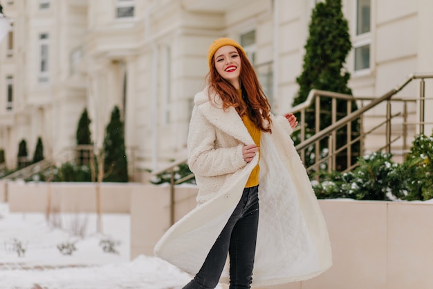 Heureux femme blanche dansant dans la matinée froide. Photo extérieure d'une fille au gingembre insouciante profitant des journées d'hiver.