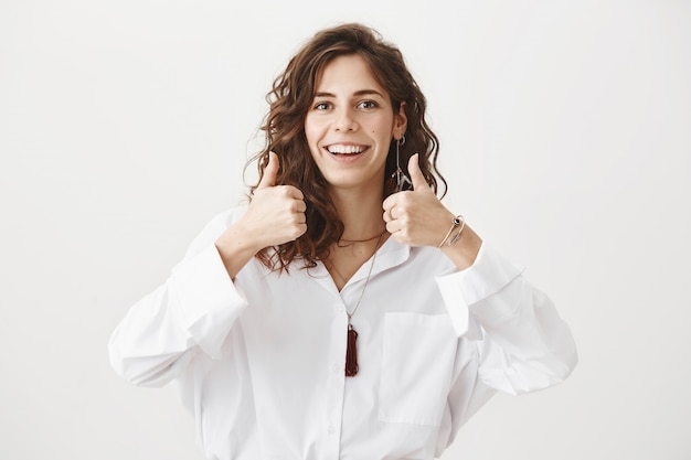 Heureux femme séduisante Thumbs-up en approbation, recommander le produit