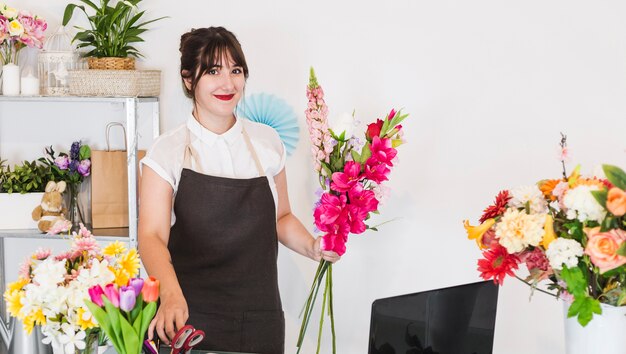 Heureux fleuriste femme avec bouquet de fleurs