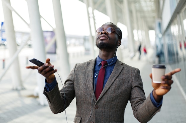 Heureux homme d&#39;affaires afro-américain danse alors qu&#39;il écoute de la musique