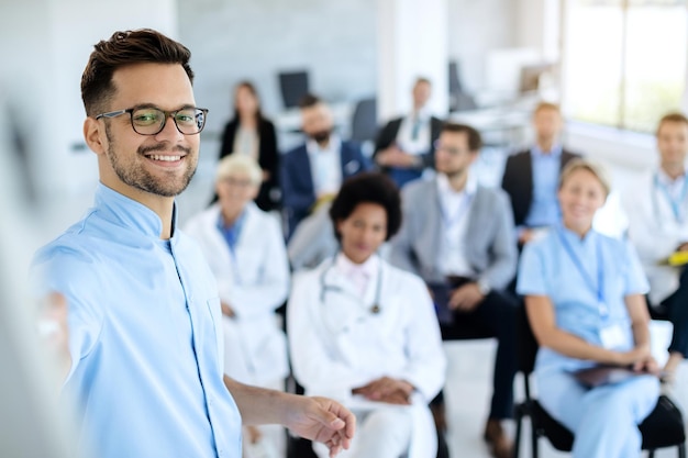 Photo gratuite heureux homme d'affaires donnant une présentation à un groupe de collègues et de médecins