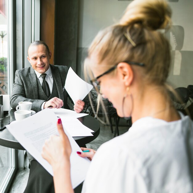 Heureux homme d&#39;affaires avec son partenaire travaillant sur un document dans un café