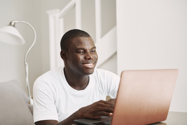 Heureux homme d'apparence africaine regarde l'éducation de l'écran d'ordinateur portable