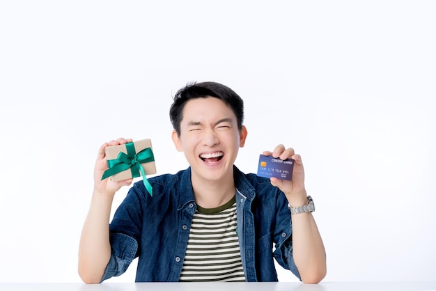 Heureux homme asiatique style de vie décontracté sourire rire main tenir carte de crédit et boîte de cadeau sortant homme asiatique avec grand succès promotion concept d'idées d'affaires