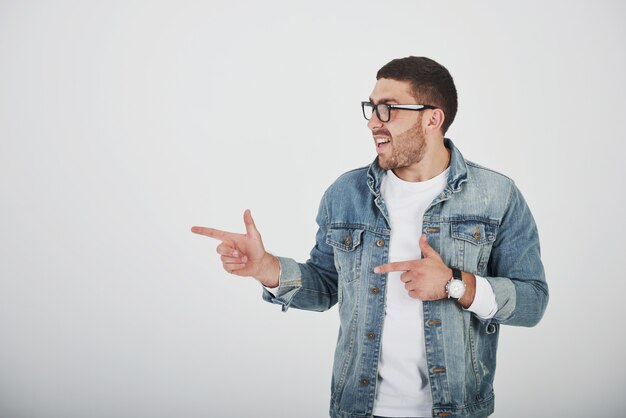 Heureux homme barbu excité à lunettes regardant la caméra avec le sourire