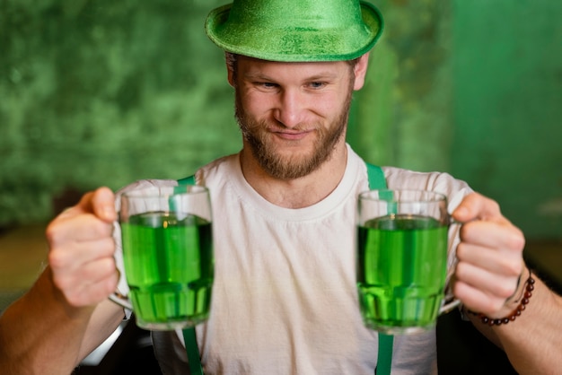 Photo gratuite heureux homme célébrant st. le jour de patrick avec des boissons