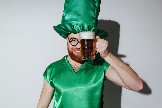 Heureux homme en costume de st.patriks tenant de la bière