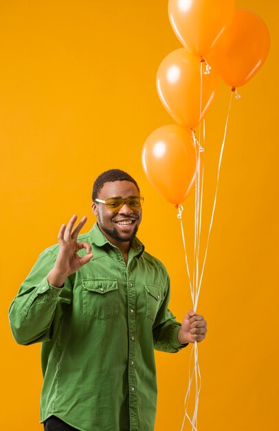 Heureux homme à la fête tenant des ballons