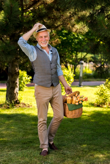 Heureux homme marchant avec un panier long shot