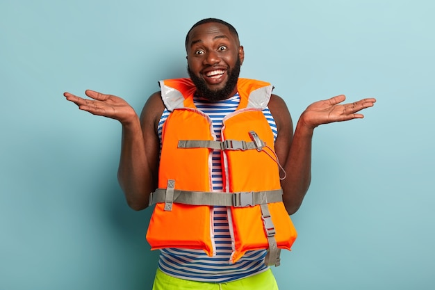 Heureux homme musclé barbu posant avec des articles de plage