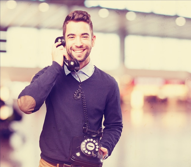 Heureux homme parlant sur un téléphone antique